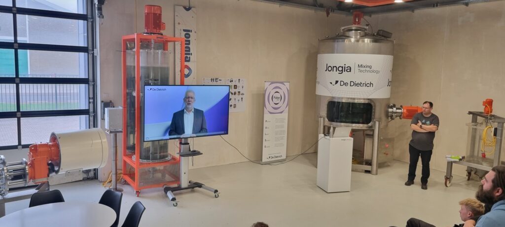 Video welcome address by CEO Jacques Moulin on a screen next to Jongia test agitators during Safety Day.
