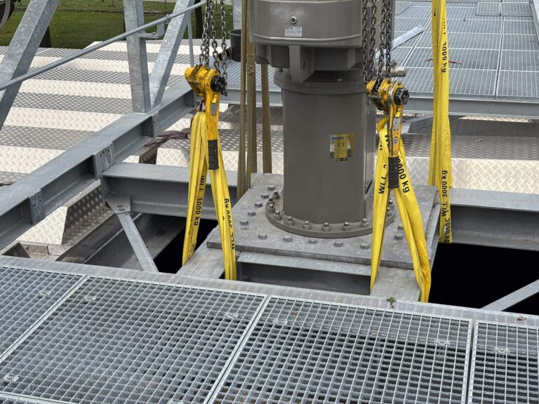 Close-up of the agitator drive on its mounting flange, with chain hoists and lifting slings attached.