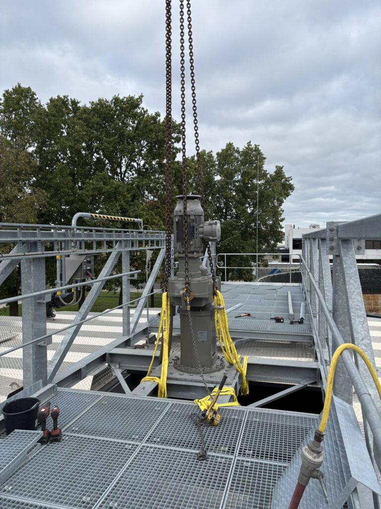 The drive of the Jongia agitator is rigged with chains and lifting slings on the bridge over the sludge mixing tank.