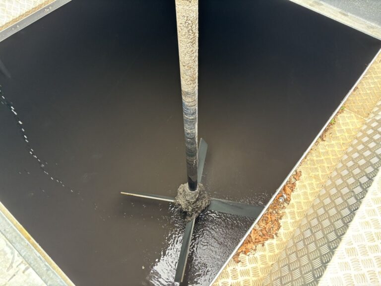 View through the bridge opening of the agitator shaft and impeller in the sludge mixing tank.