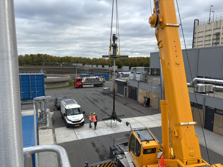 The crane lowers the Jongia agitator to the ground at WWTP Venlo, with the treatment basins in the background.
