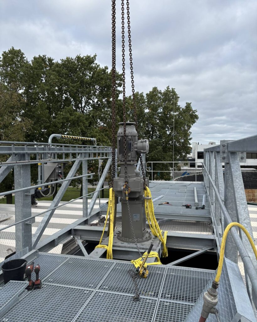 The drive of the Jongia agitator is rigged with chains and lifting slings on the bridge over the sludge mixing tank.