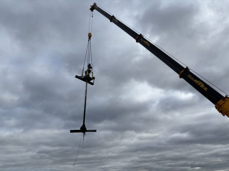 The complete Jongia agitator, with drive, long shaft and impeller, lifted high above WWTP Venlo by a mobile crane.